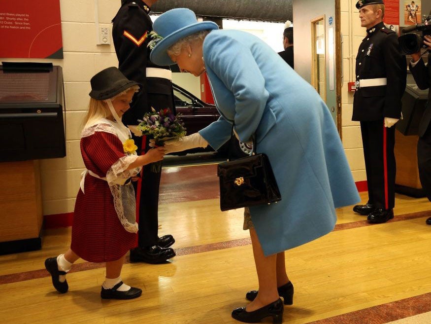 Maisie Gregory gave the Queen flowers before a soldier accidentally knocked her hat off as he saluted the departing monarch