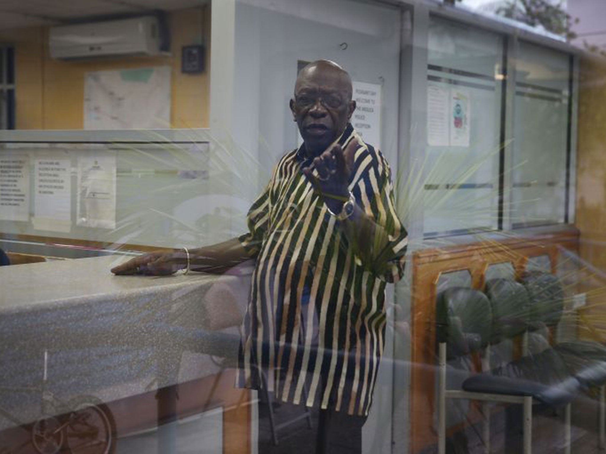 Former Fifa vice-president Jack Warner reacts to being photographed as he waits to sign in at the front desk of the Arouca Police Station as required under his bail agreement on June 11, 2015 in Arouca, Trinidad And Tobago.