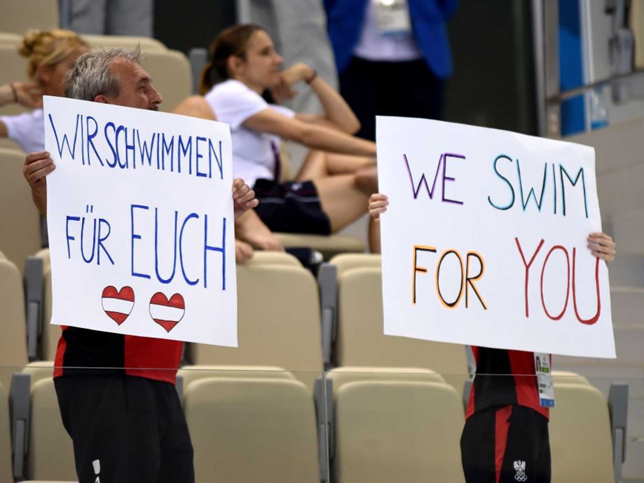 Supporters hold up signs as the Austrian swim team compete in Azerbaijan