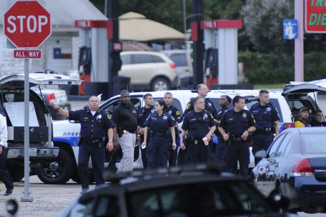 Dallas Police officers gather at Dowdy Ferry Road and Interstate 45 in Hutchins during a standoff. A suspect in the attack of the Dallas Police Headquarters believed to be James Boulware was shot by a Dallas Police sniper in the car park of a restaurant i