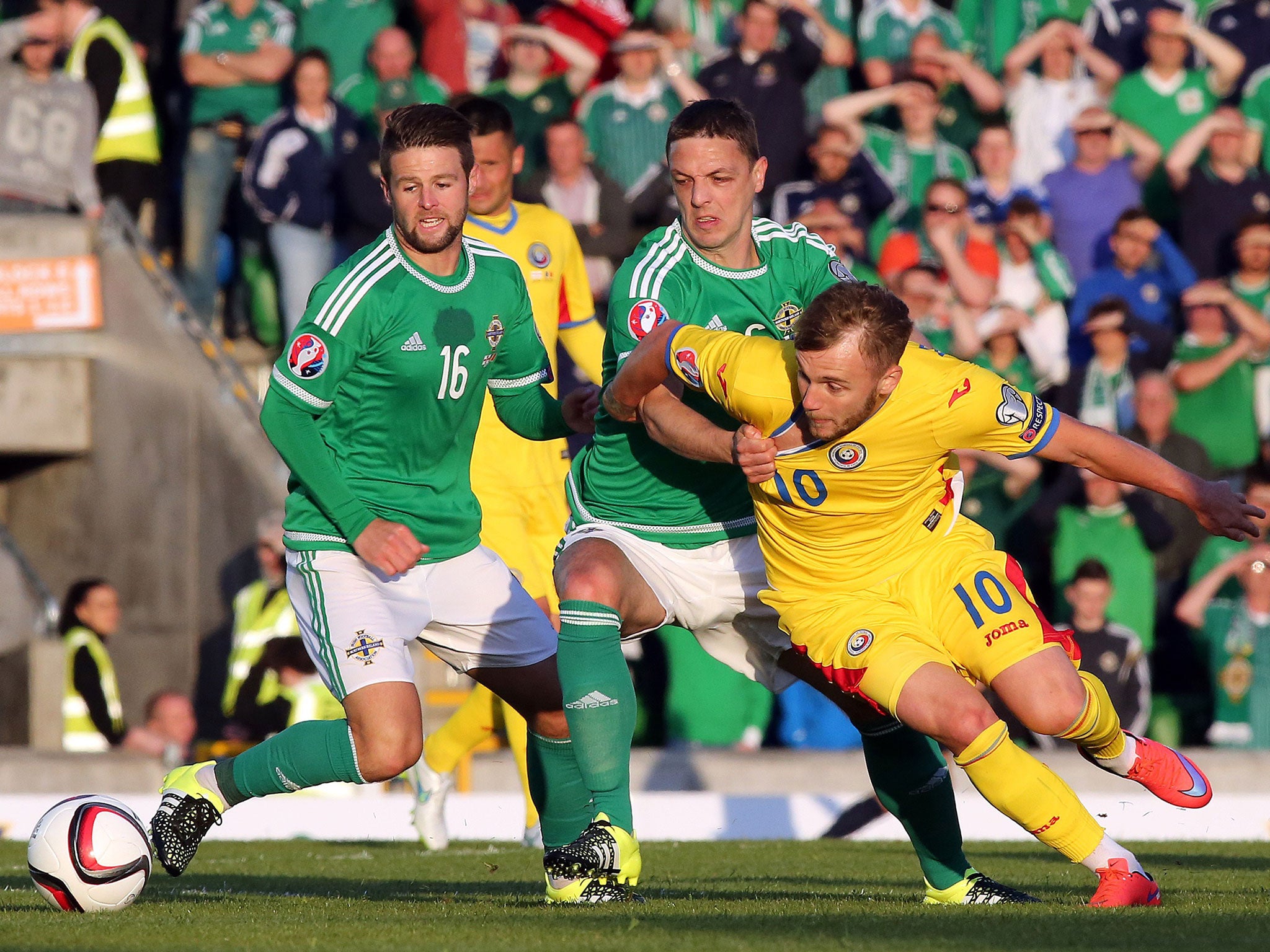 Northern Ireland's midfielder Oliver Norwood (L) and defender Chris Baird (2nd R) vie with Romania's midfielder Ivan Lorenzo