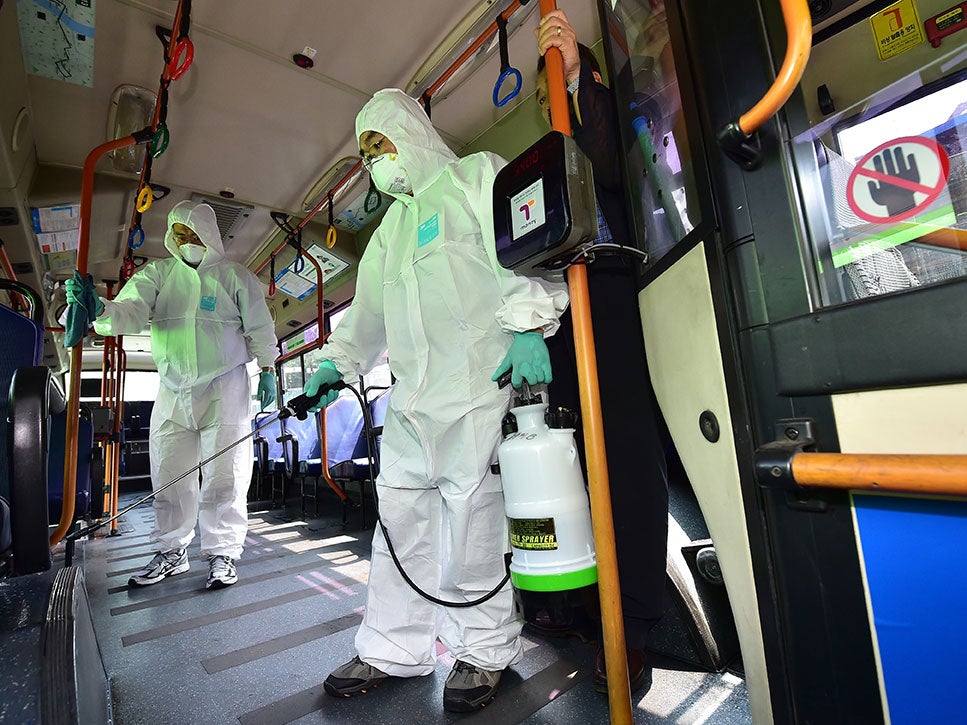 Health workers sanitising a public bus in Seoul, South Korea