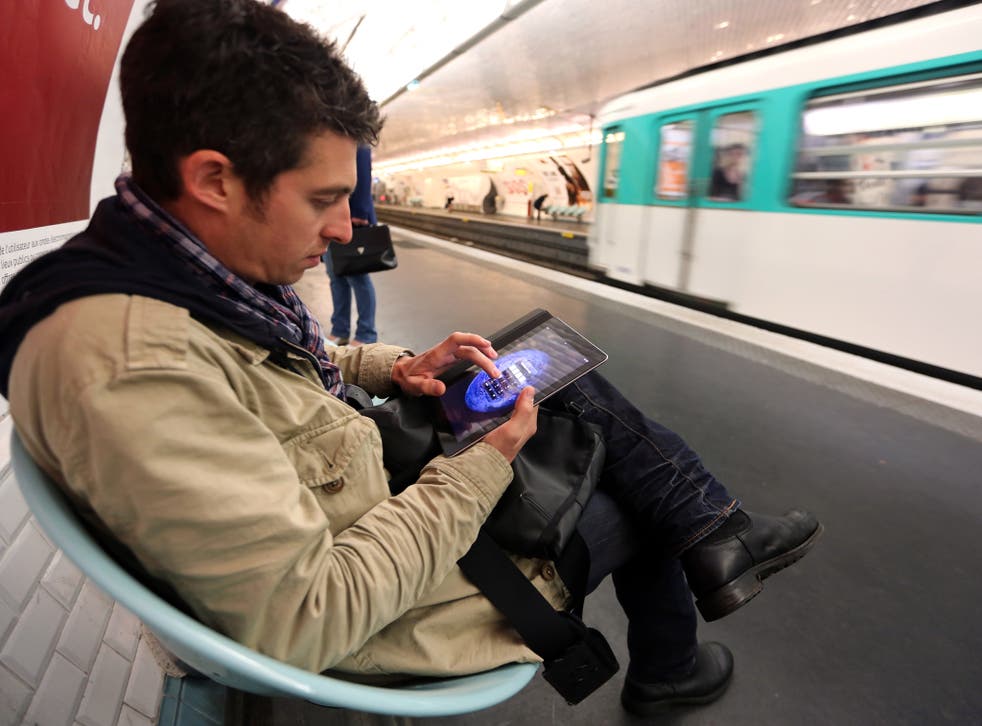A man poses with a tablet on June 26, 2012, in the Parisian metro, on the inauguration day of a free Wi-Fi access available in forty-six Paris' public transportation sites including platforms of three underground stations