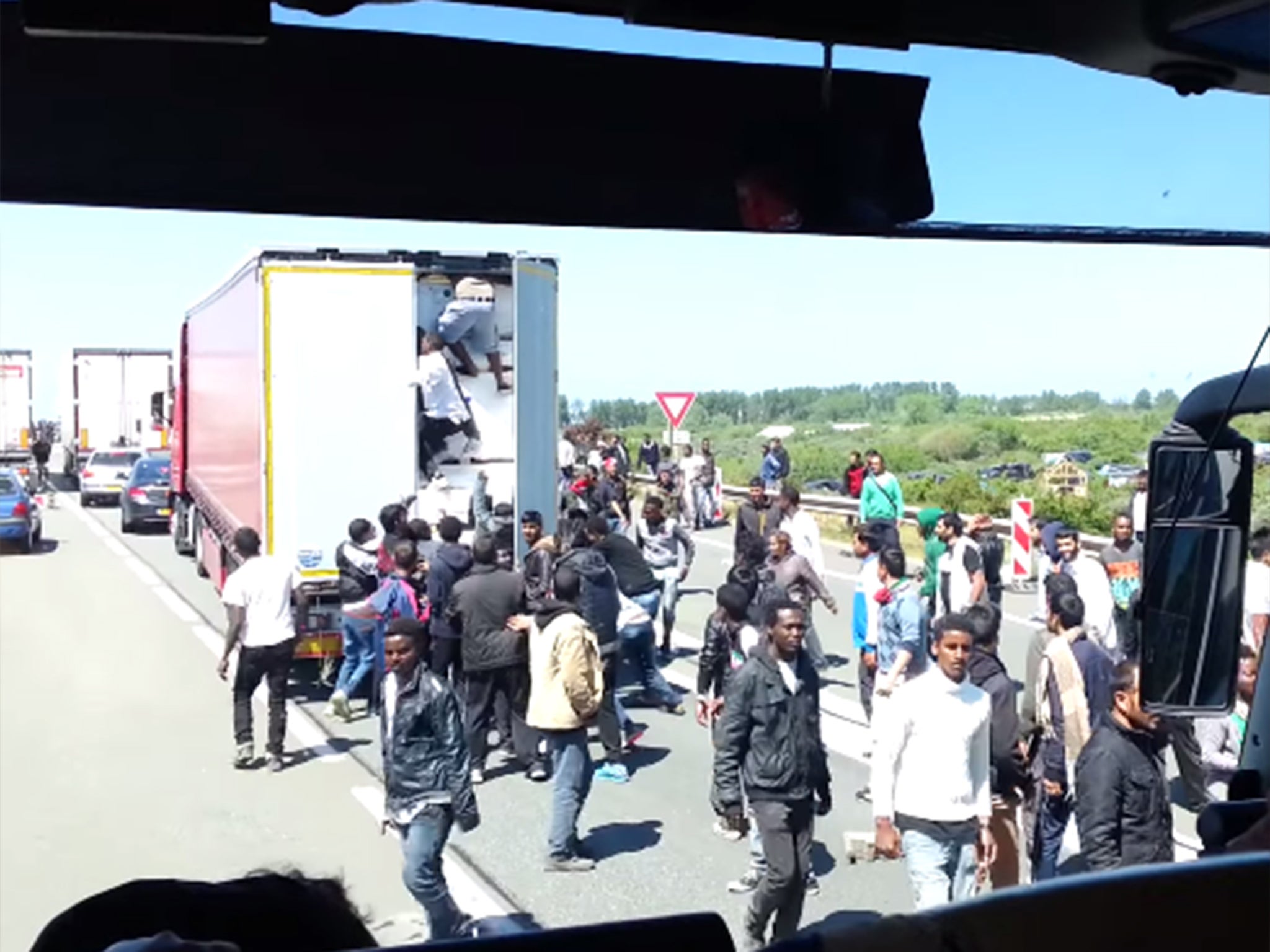 Migrants board a lorry leaving Calais
