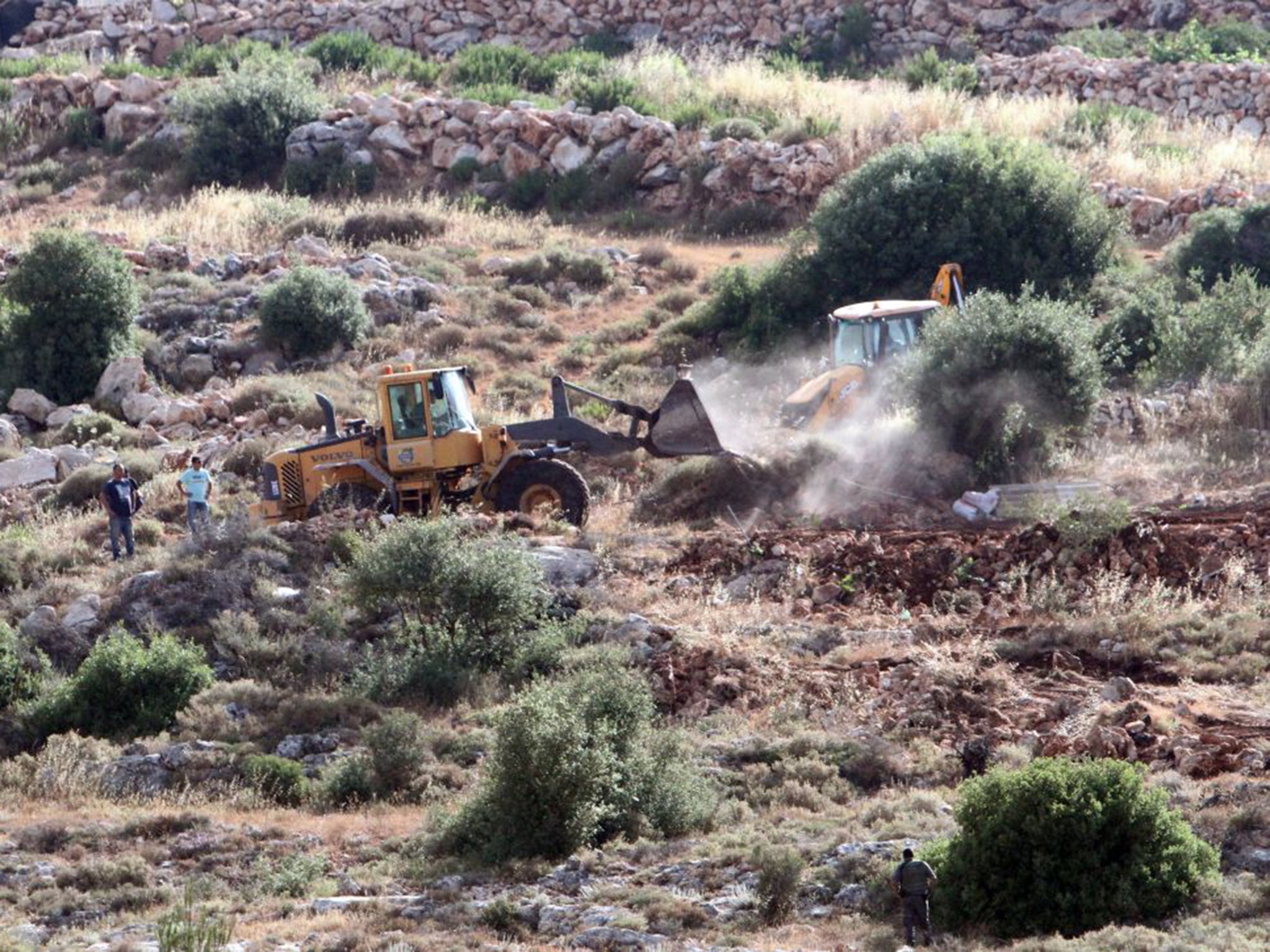 Bulldozers clear land for a new settlement in the West Bank village of Wadi Fukin last week