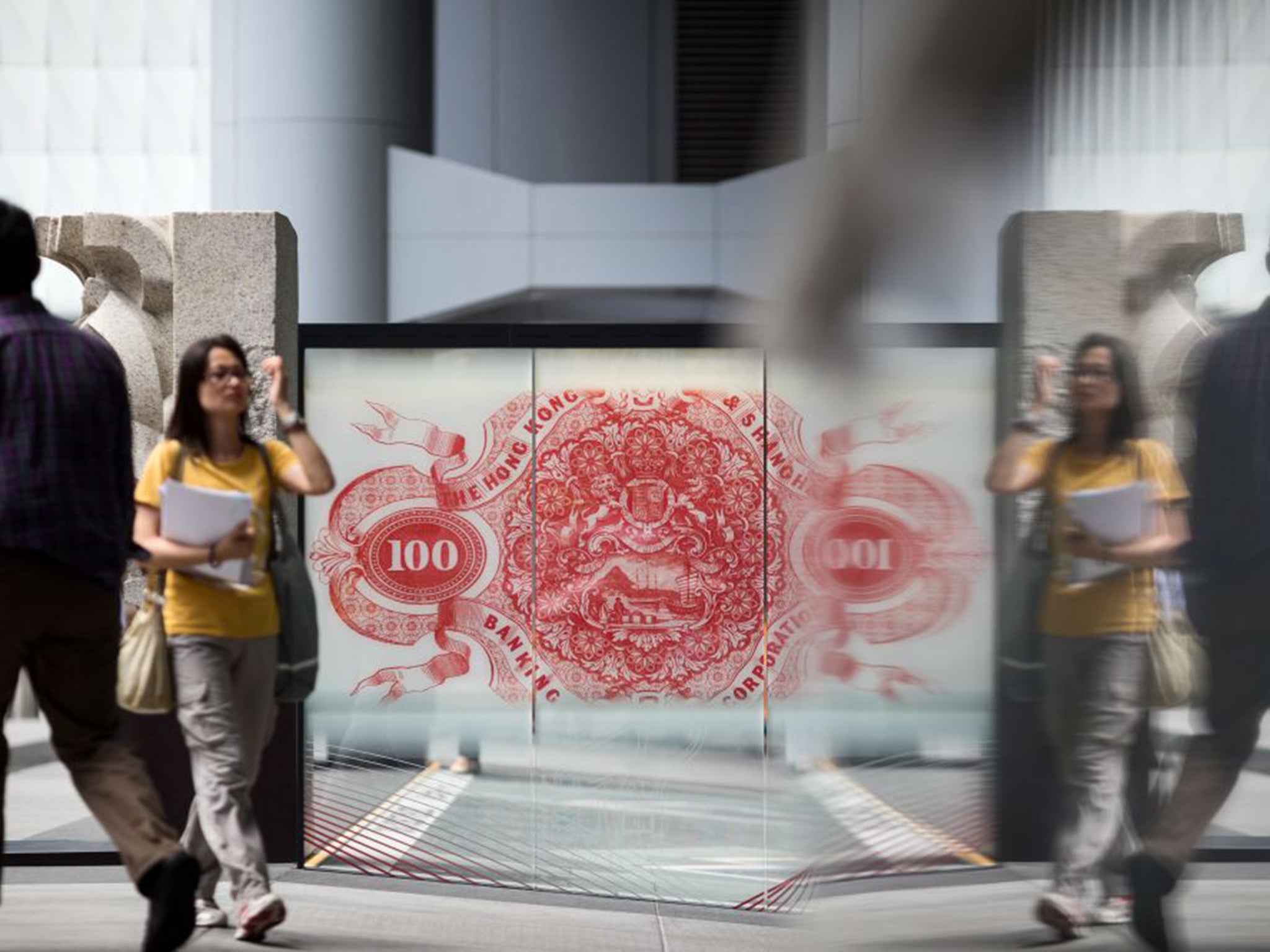 A giant Hong Kong $100 banknote stands in the window of HSBC’s Asia headquarters, but local citizens are worried about competition for jobs as links to the Pearl River delta region are strengthened