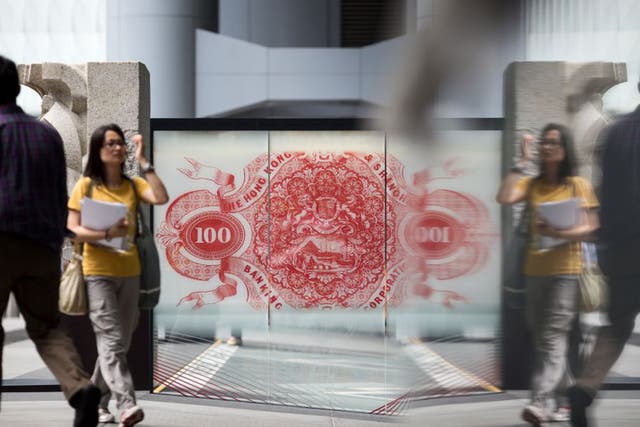 A giant Hong Kong $100 banknote stands in the window of HSBC’s Asia headquarters,  but local citizens are worried about competition for jobs as links to the Pearl River delta region are strengthened
