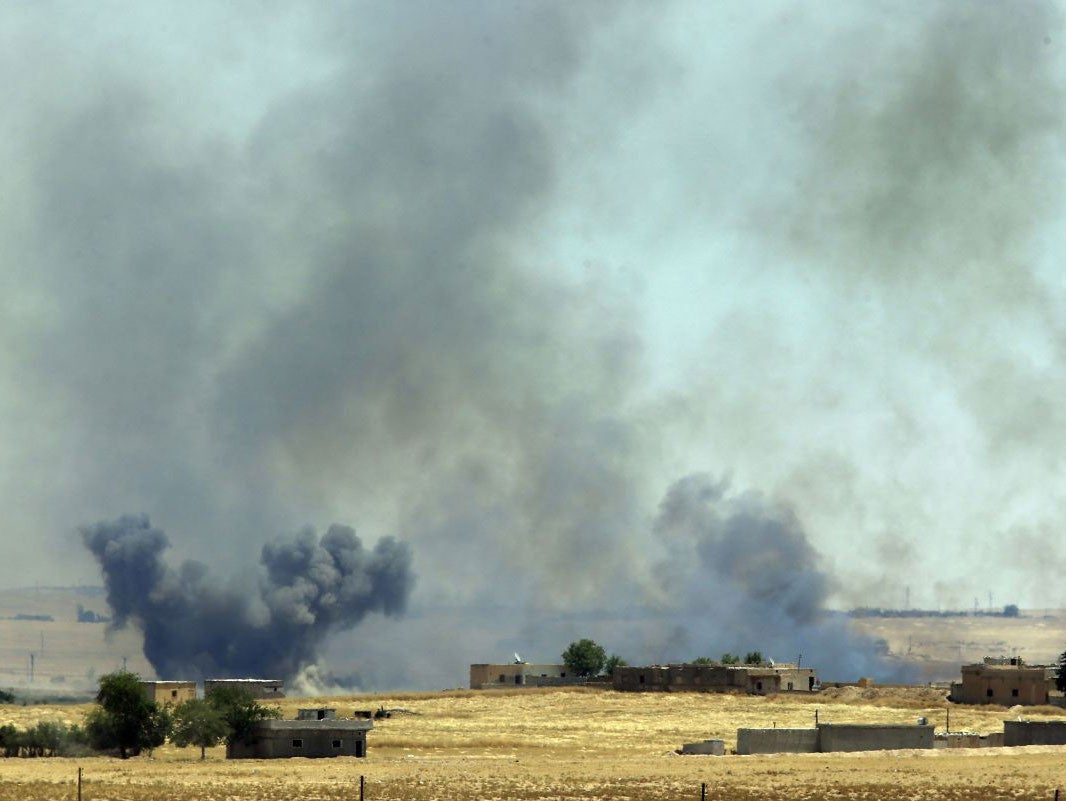 Smoke from a US-led airstrike rises over the outskirts of Tal Abyad, Syria, Sunday, June 14,