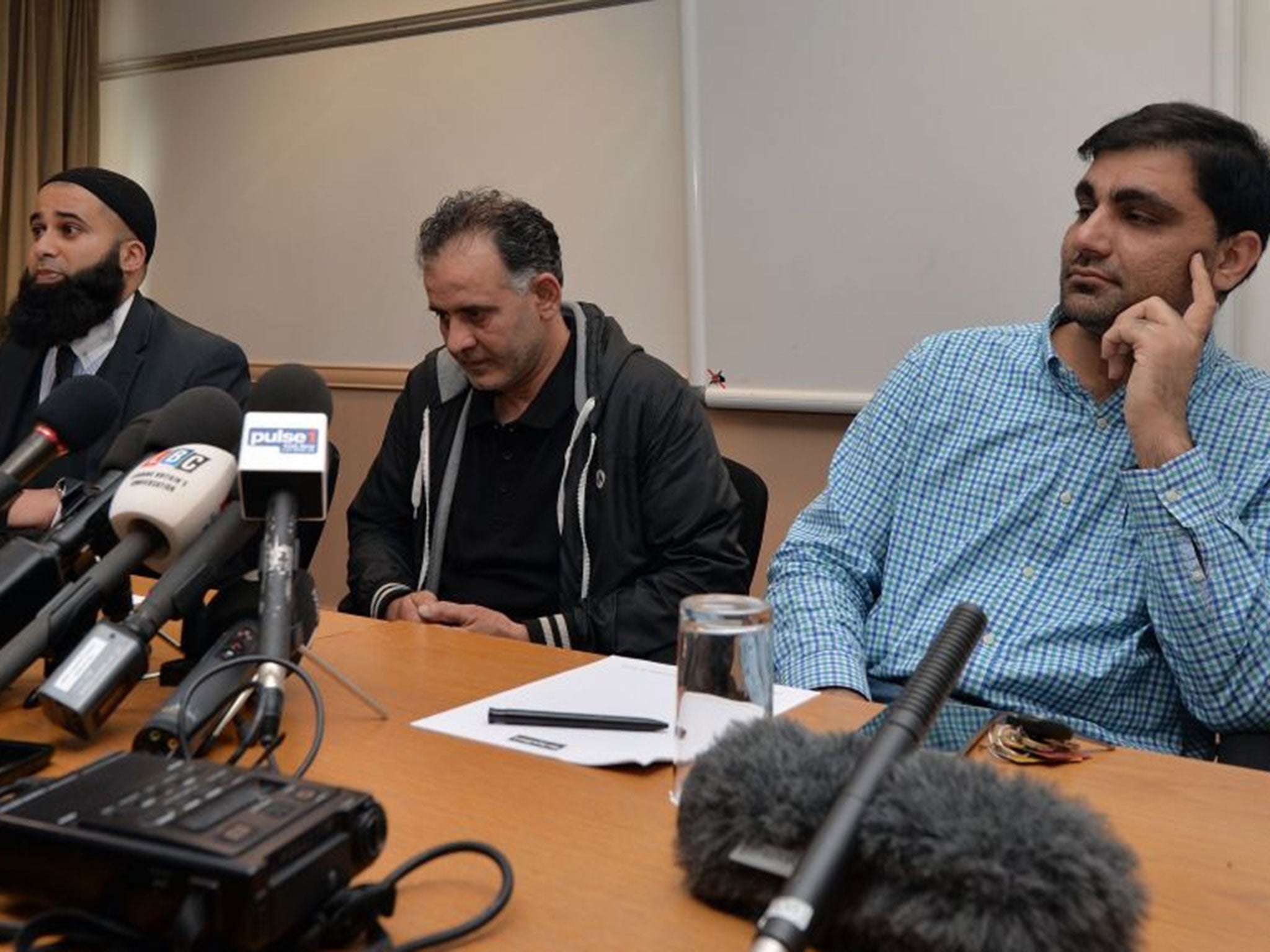 Akhtar Iqbal (centre) and Mohammad Shoaib (right) sit with their solicitor Balaal Khan during a news conference to appeal for the return of their missing wives and children (Image: AFP)