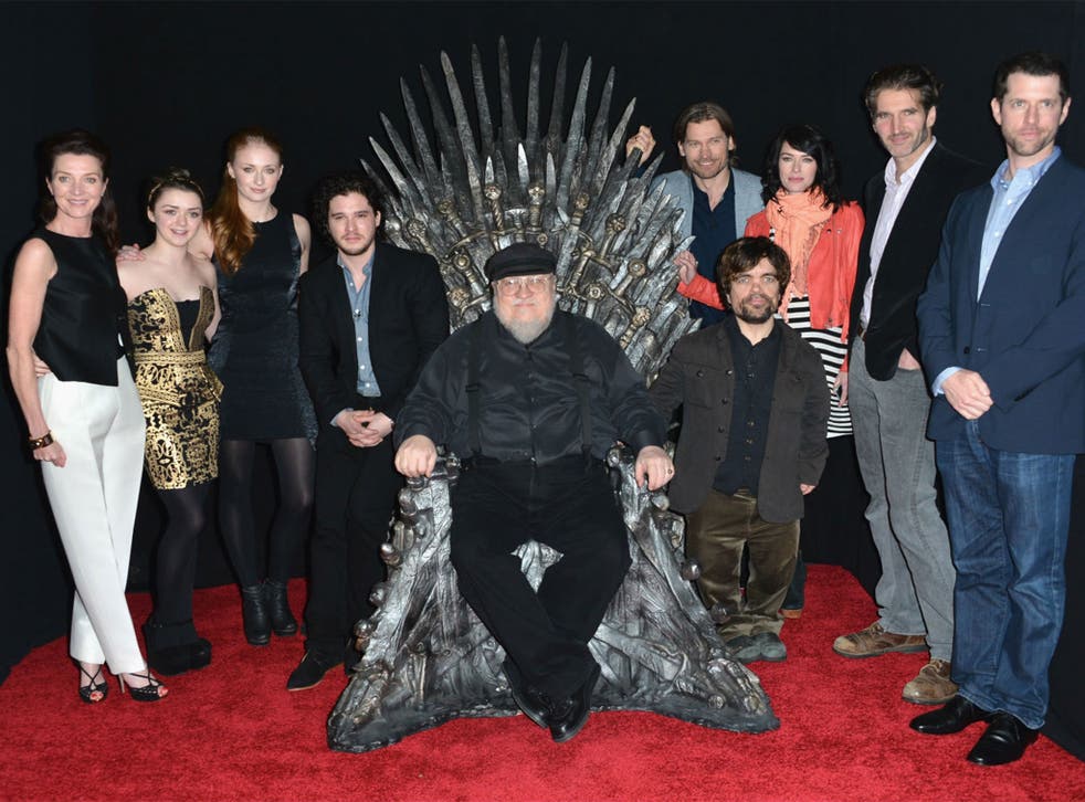 George RR Martin on the Iron Throne surrounded by past and present members of the Game of Thrones cast