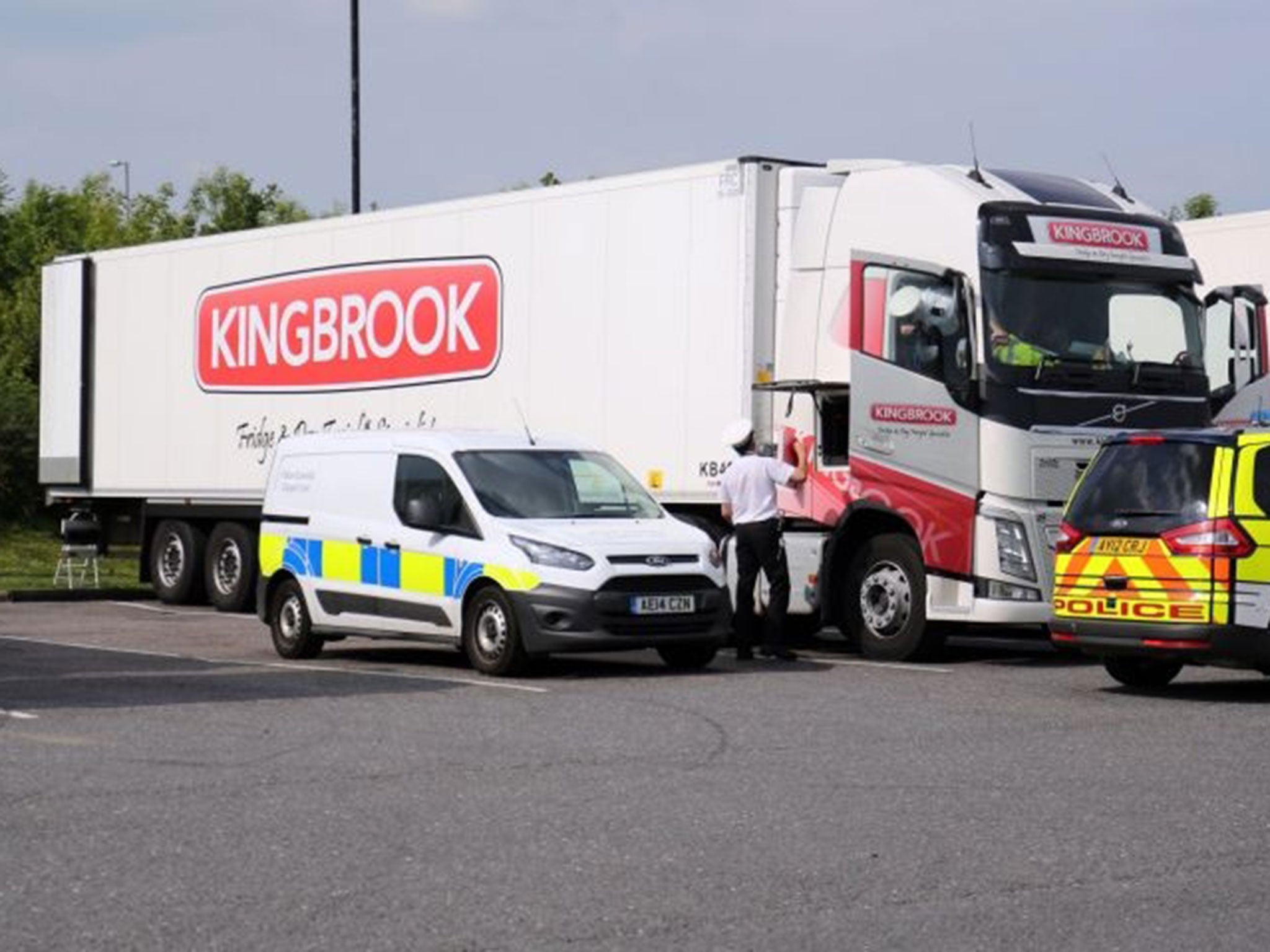 Police search a lorry at Peterborough services in Cambridgeshire after 26 suspected illegal immigrants, including teenagers, were found in the back of the vehicle.