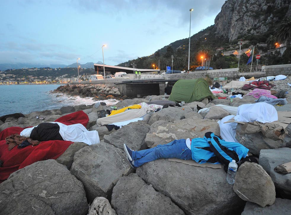 Migrants sleep by the sea yesterday in Ventimiglia, Italy, near the French border, which they have been barred from crossing