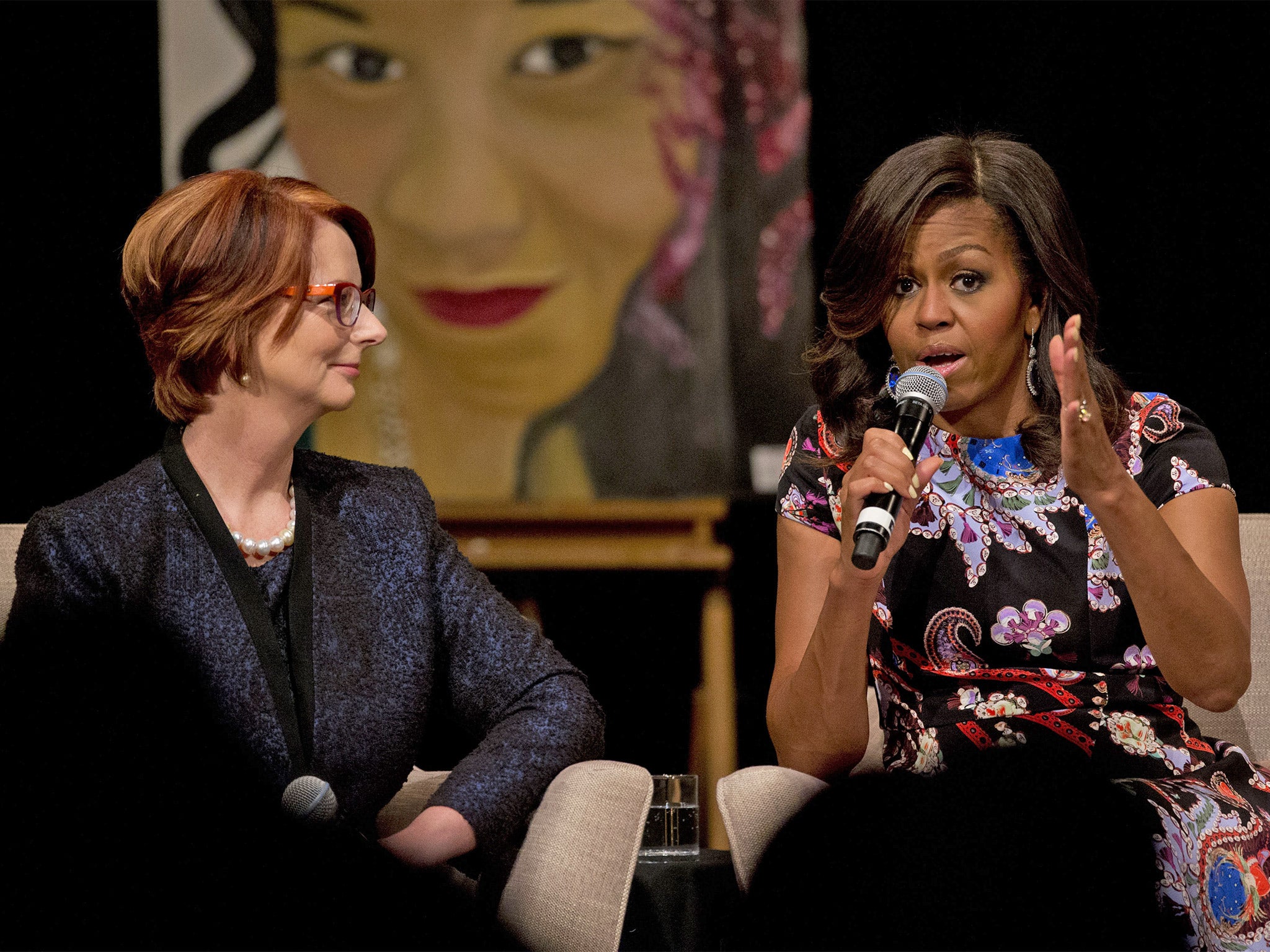 Michelle Obama speaks with former Australia Prime Minister Julia Gillard as they take part in a question and answer session at Mulberry School for Girls