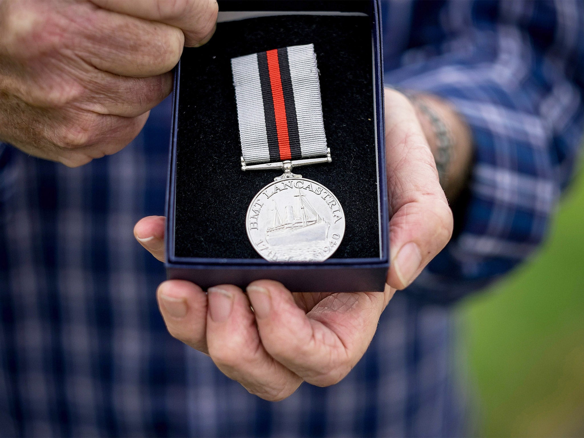 Tony Buss, 75, holds his father’s ‘HMT Lancastria’ medal