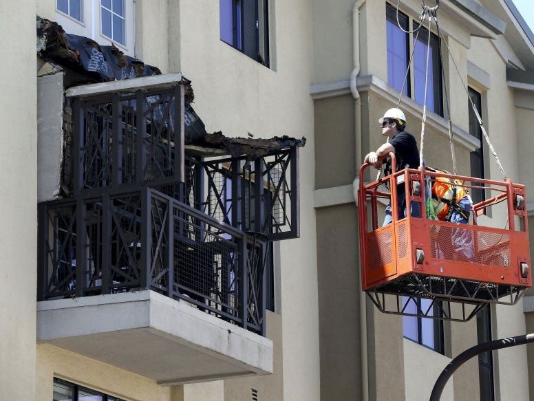 Workmen examine the damage at the scene of the collapse in Berkeley