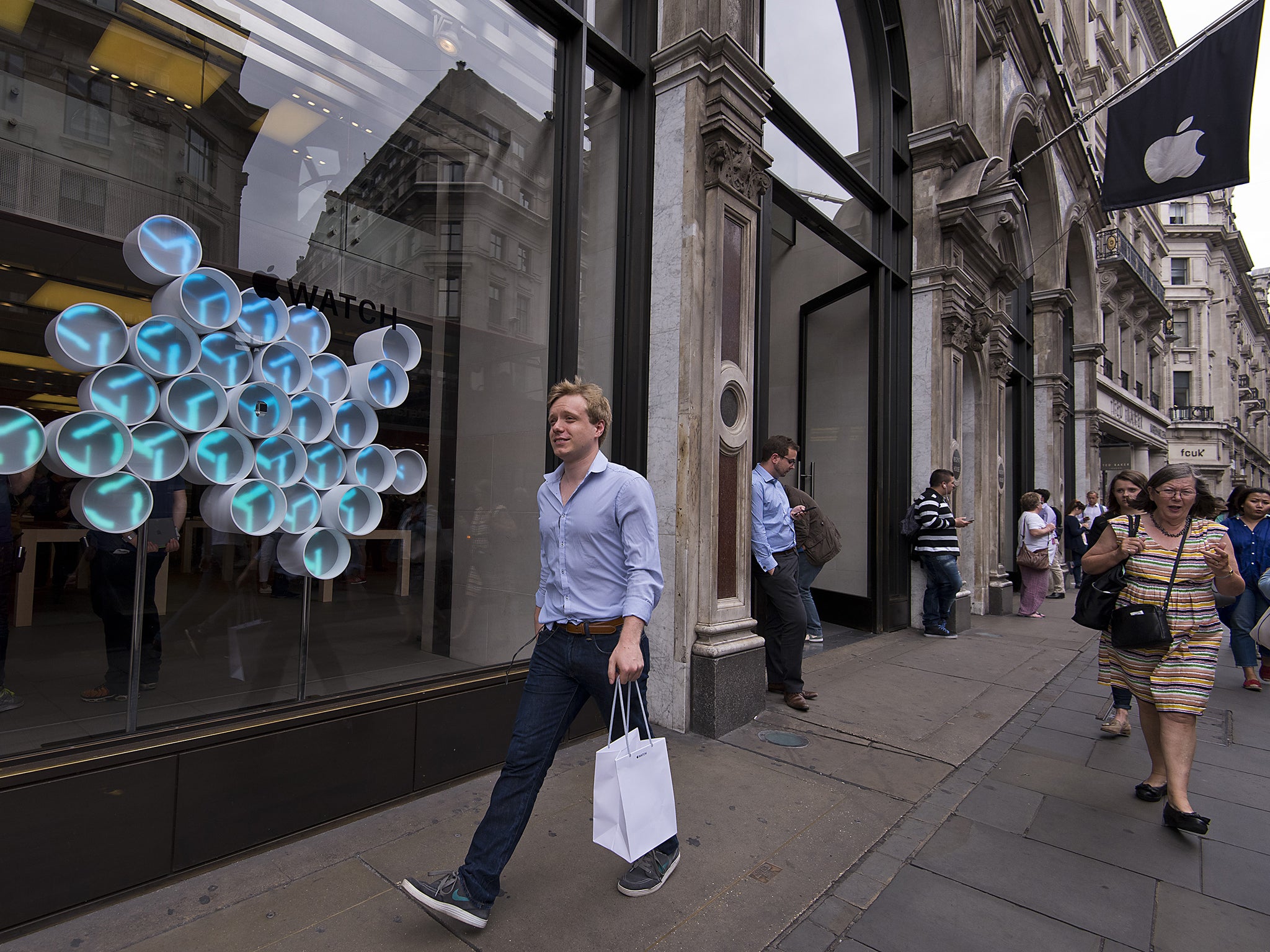 A customer leaves the Regent Street Apple Store after having picked up a Watch