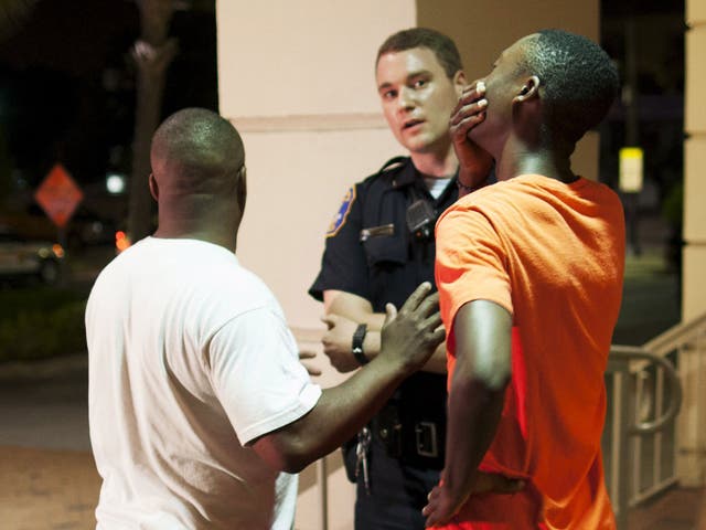 An armed police officer moves up Calhoun Street following a shooting 