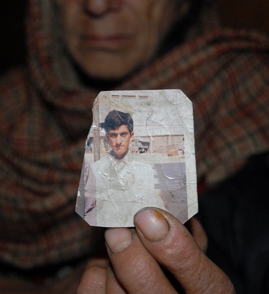 Shafqat Hussain's mother holds a photograph of her son from when he was a teenager