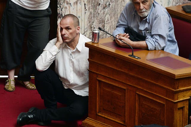 Greek Finance Minister Yianis Varoufakis  (L) listens to the Prime Minister Alexis Tsipras addressing his MP's and ministers at the Greek Parliament