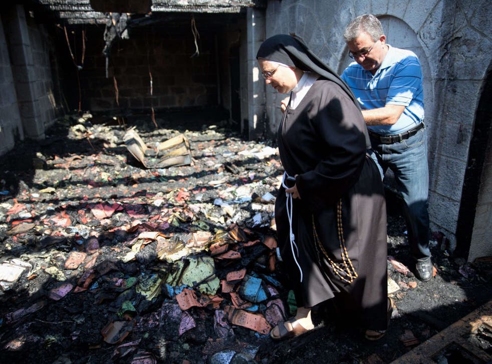 A nun inspects the damage at the Church of the Multiplication at Tabgha
