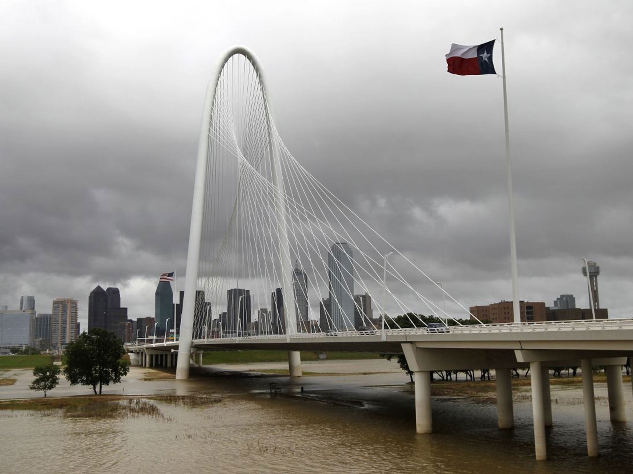 The swollen Trinity river flows beneath the Margaret Hunt Hill bridge, Dallas