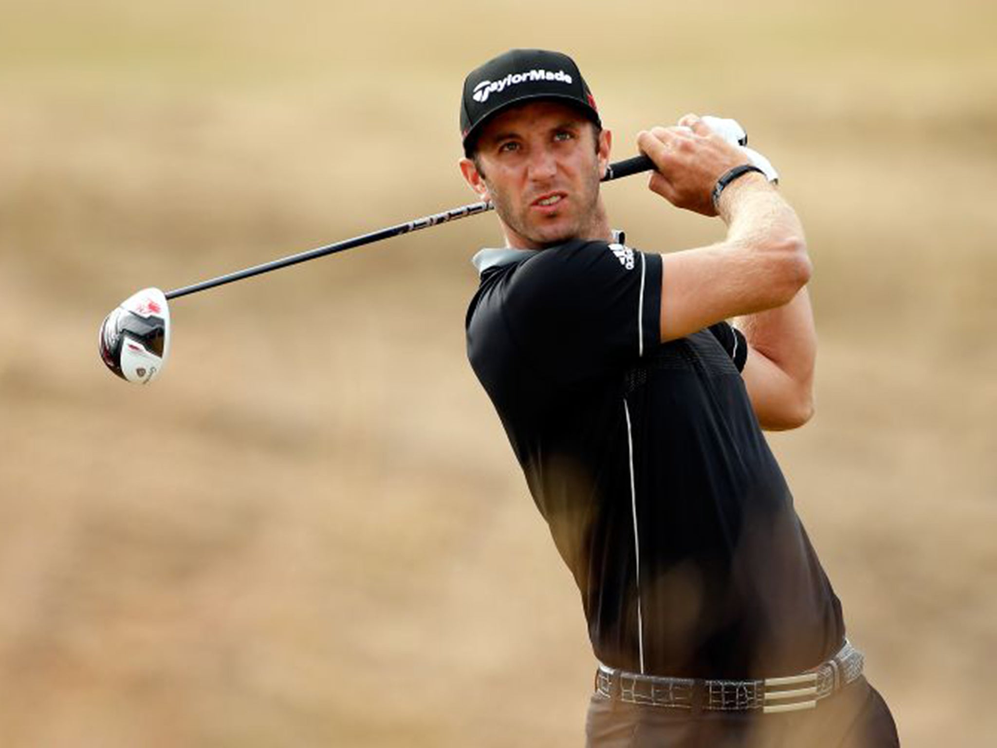 Dustin Johnson hits a drive at Chambers Bay on his way to an opening 65 on Thursday