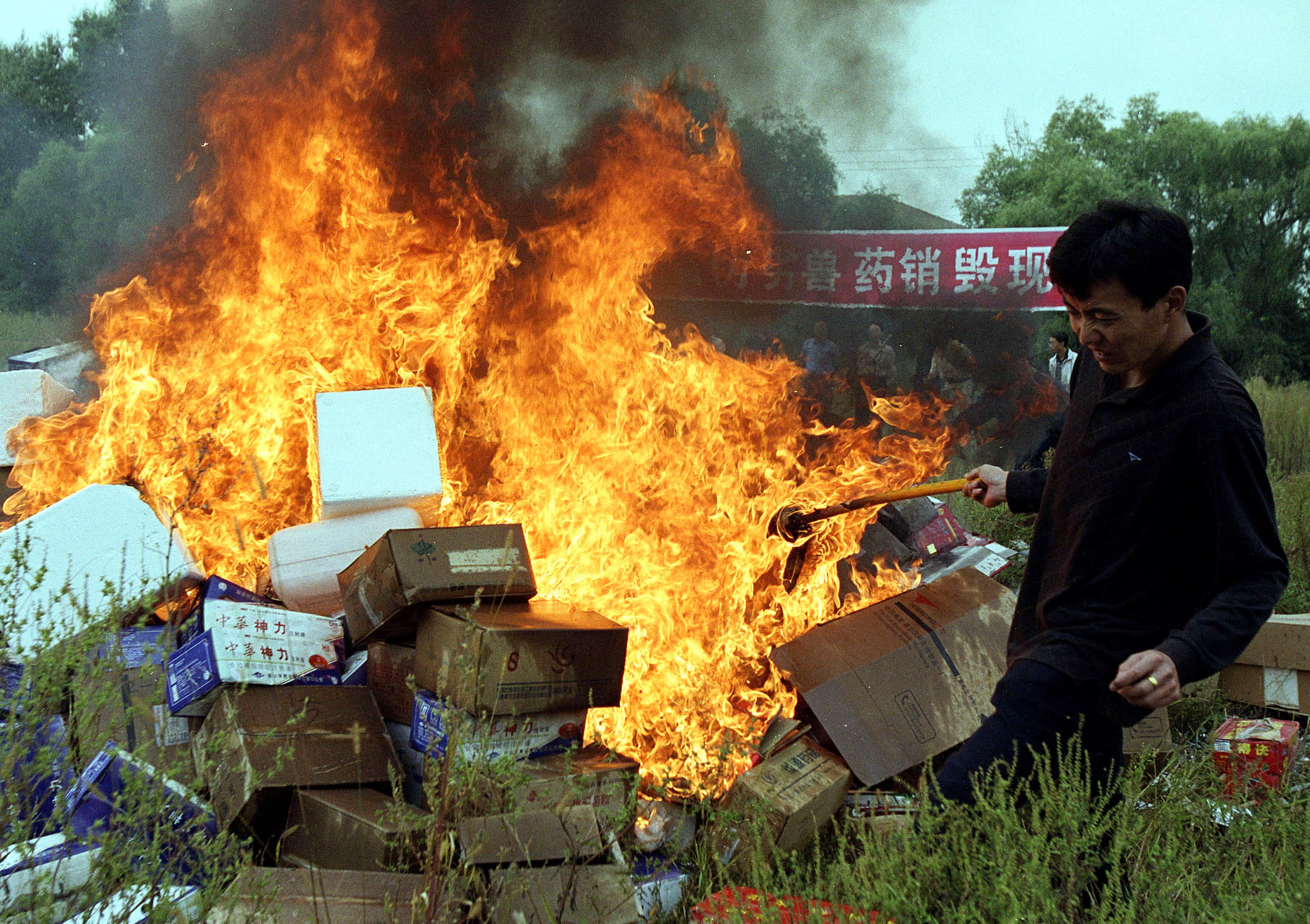 A man burns fake animal medicine in China in 2013.