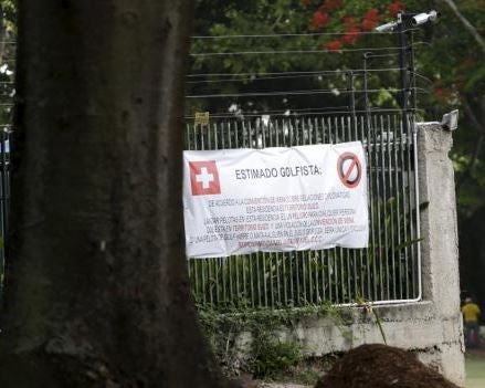 A large placard is seen on the fence of the residence of Switzerland's ambassador to Venezuela near the third of the Caracas Country Club's 18 holes in Caracas June 17, 2015.