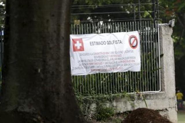 A large placard is seen on the fence of the residence of Switzerland's ambassador to Venezuela near the third of the Caracas Country Club's 18 holes in Caracas June 17, 2015.