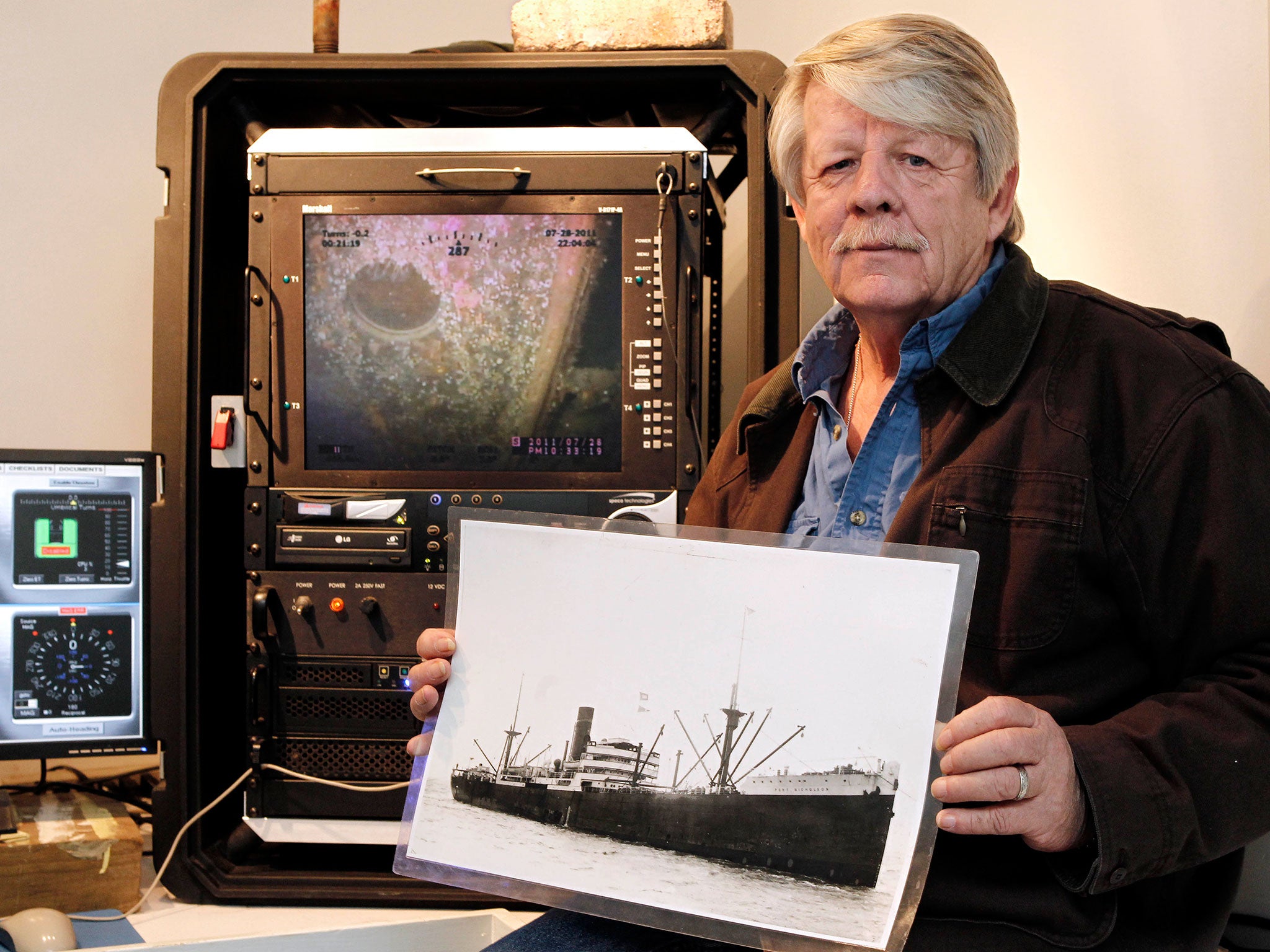 Greg Brooks, co-manager of Sub Sea Research, is seen aboard the salvage ship Sea Hunter in Boston Harbor Wednesday, Feb. 1, 2012 holding a picture of the British merchant ship Port Nicholson