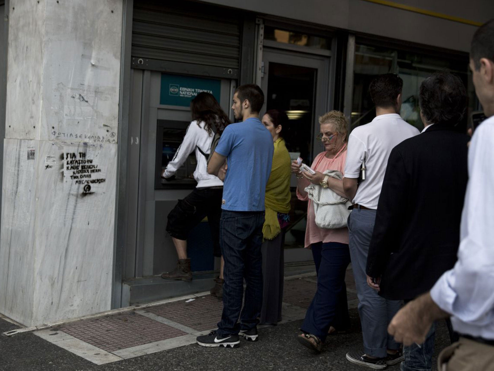 People line up at an ATM outside a branch of the National Bank, in central Athens, on Friday, June 19, 2015. Greece failed to secure a deal with bailout creditors on Friday, prompting the European Union to calls an emergency leaders' meeting for Monday.