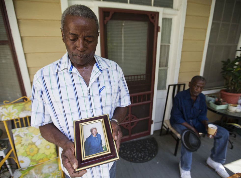 Walter Jackson, left, holds a photo of his mother Susie Jackson, one of the nine people killed in Wednesday's shooting at Emanuel AME Church