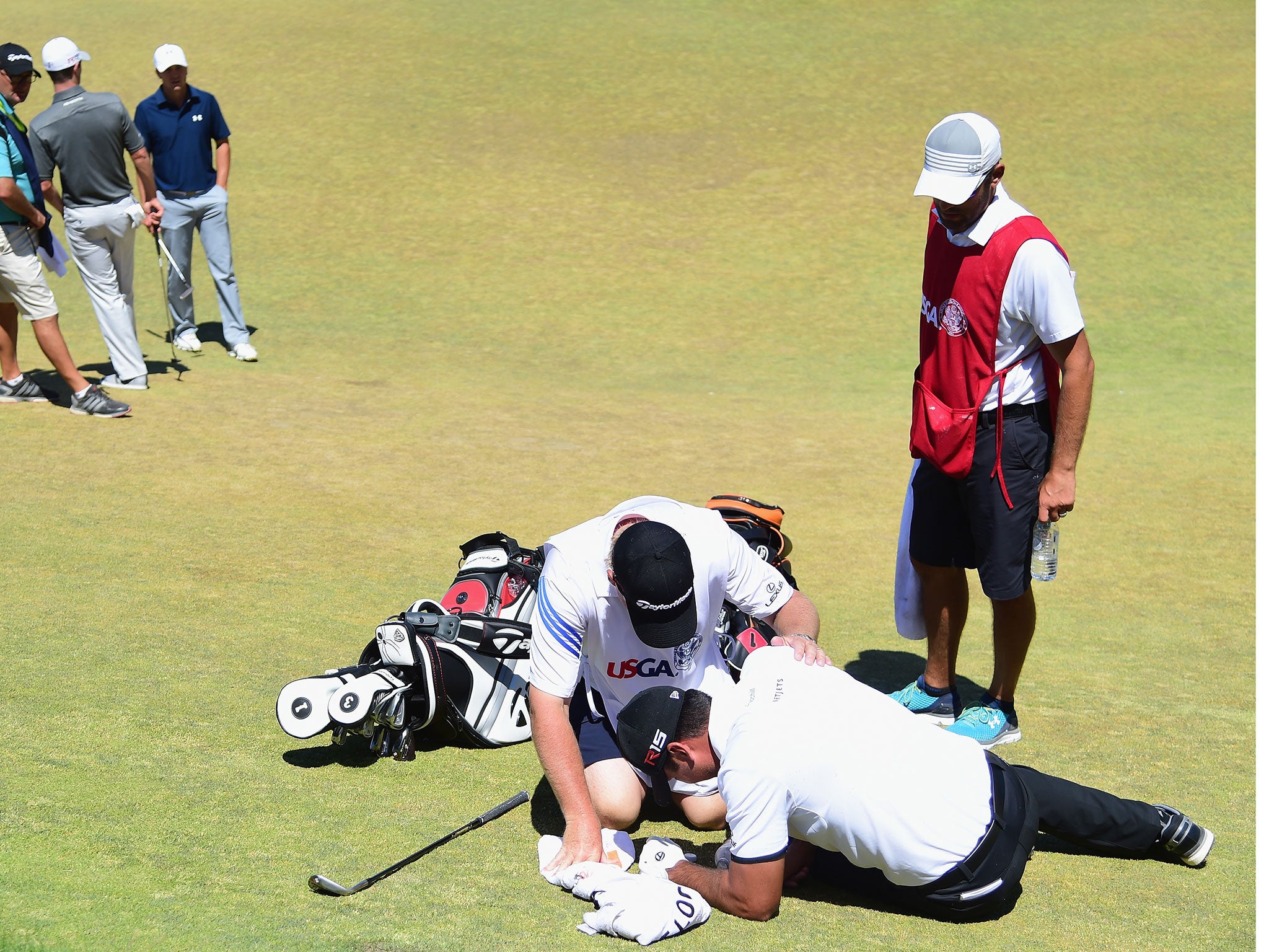Jason Day receives treatment after collapsing during the second round
