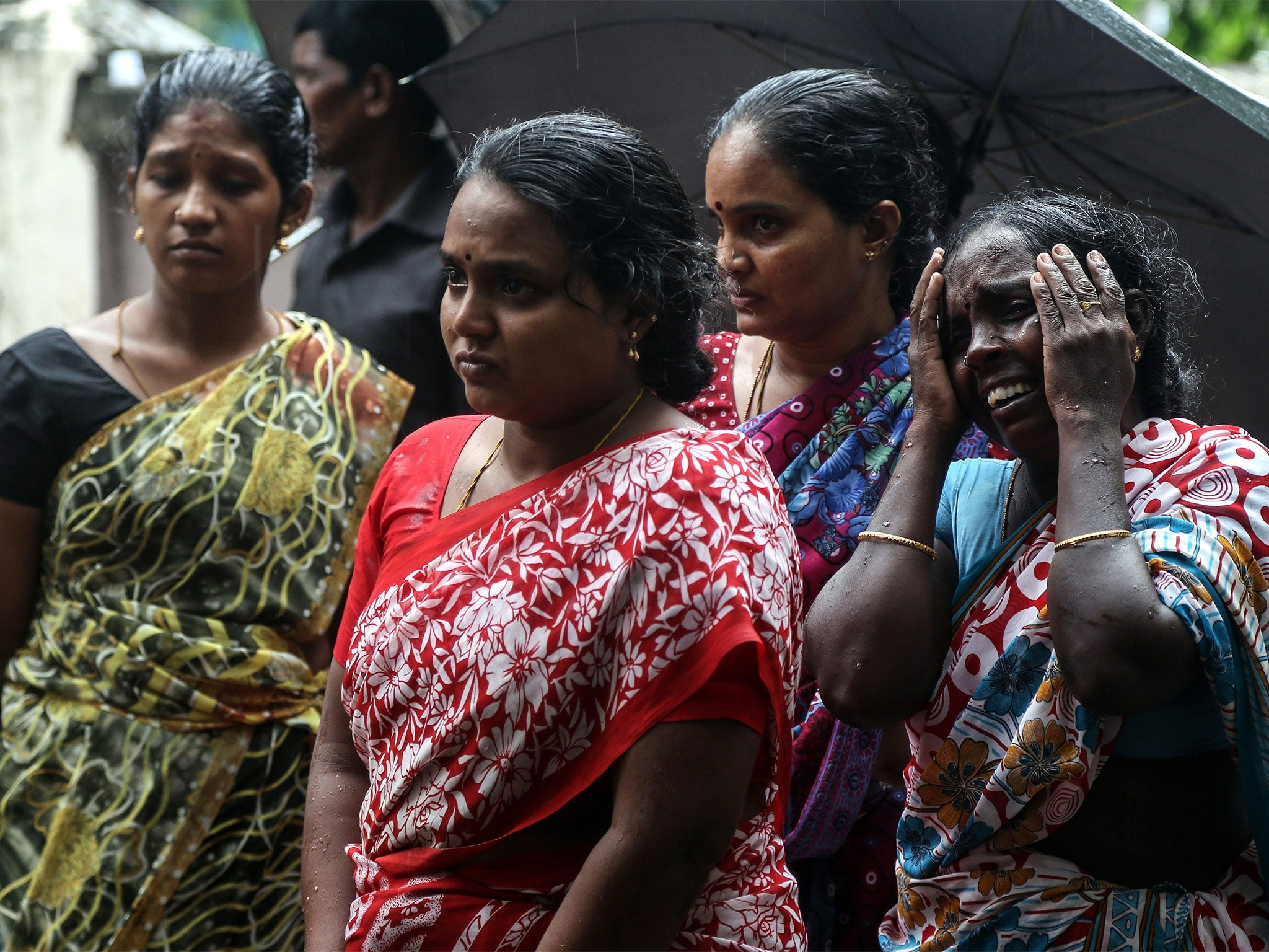 Relatives mourn in Mumbai after dozens died from drinking illegal alcohol