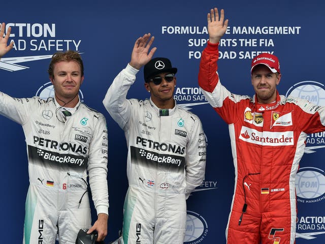 Lewis Hamilton celebrates taking pole alongside Nico Rosberg (l) and Sebastian Vettel (r)