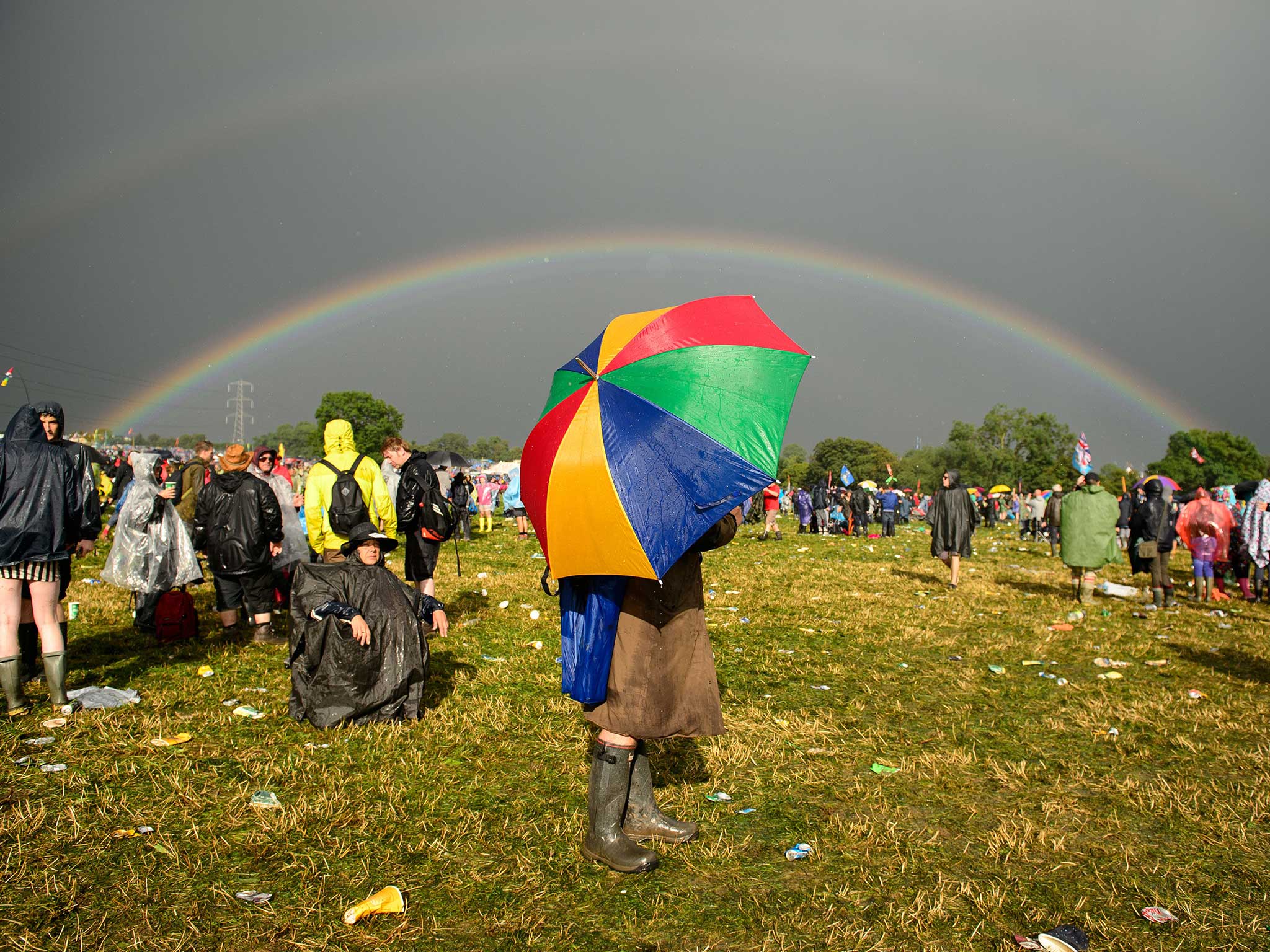 A Glastonbury reveller hides under an umbrella at the festival last year
