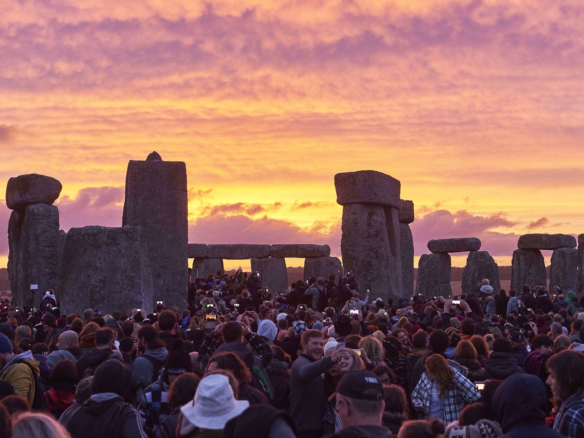 Revellers watch the sunrise as they celebrate the pagan festival of Summer Solstice at Stonehenge in Wiltshire. The festival, which dates back thousands of years, celebrates the longest day of the year when the sun is at its maximum elevation. Modern drui