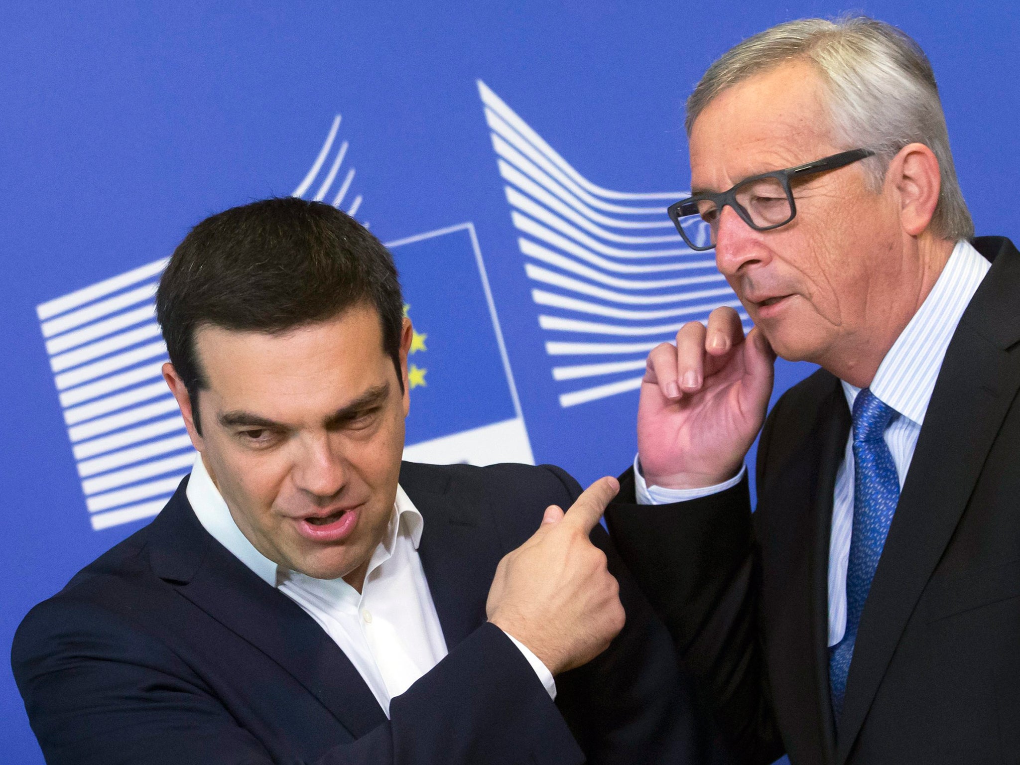 Greece’s Prime Minister Alexis Tsipras, left is welcomed by European Commission President Jean-Claude Juncker ahead of the summit on Monday