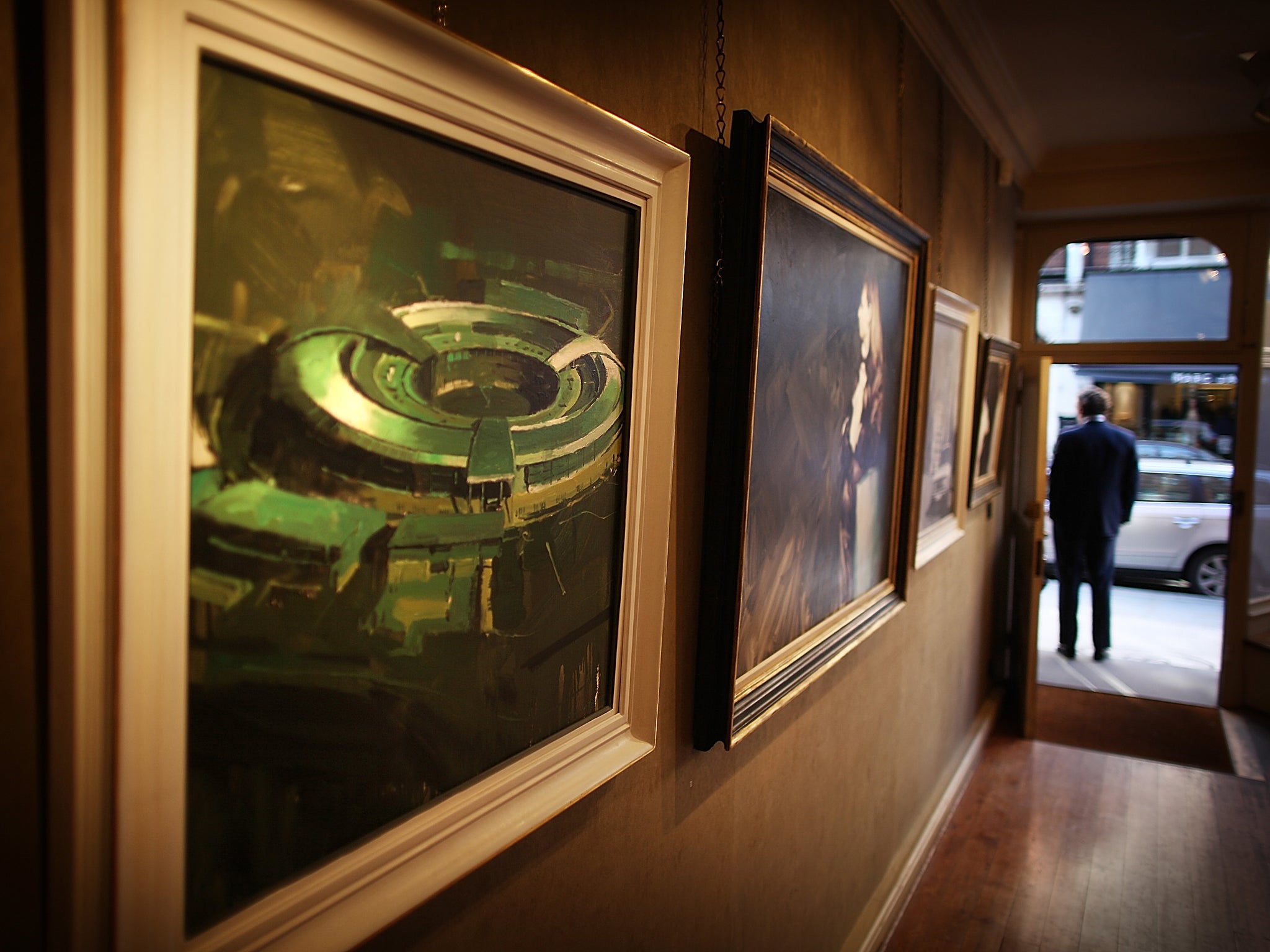 A painting of the government listening station GCHQ (L) is displayed at the 'A Year with MI6' exhibition at the Mount Street Gallery on February 14, 2011 in London, England