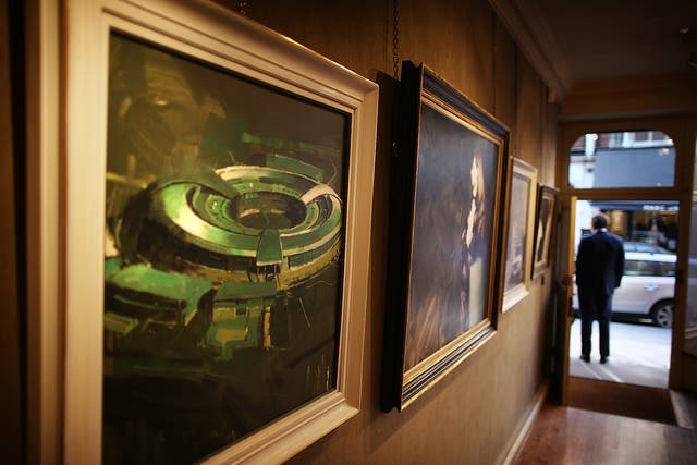 A painting of the government listening station GCHQ (L) is displayed at the 'A Year with MI6' exhibition at the Mount Street Gallery on February 14, 2011 in London, England