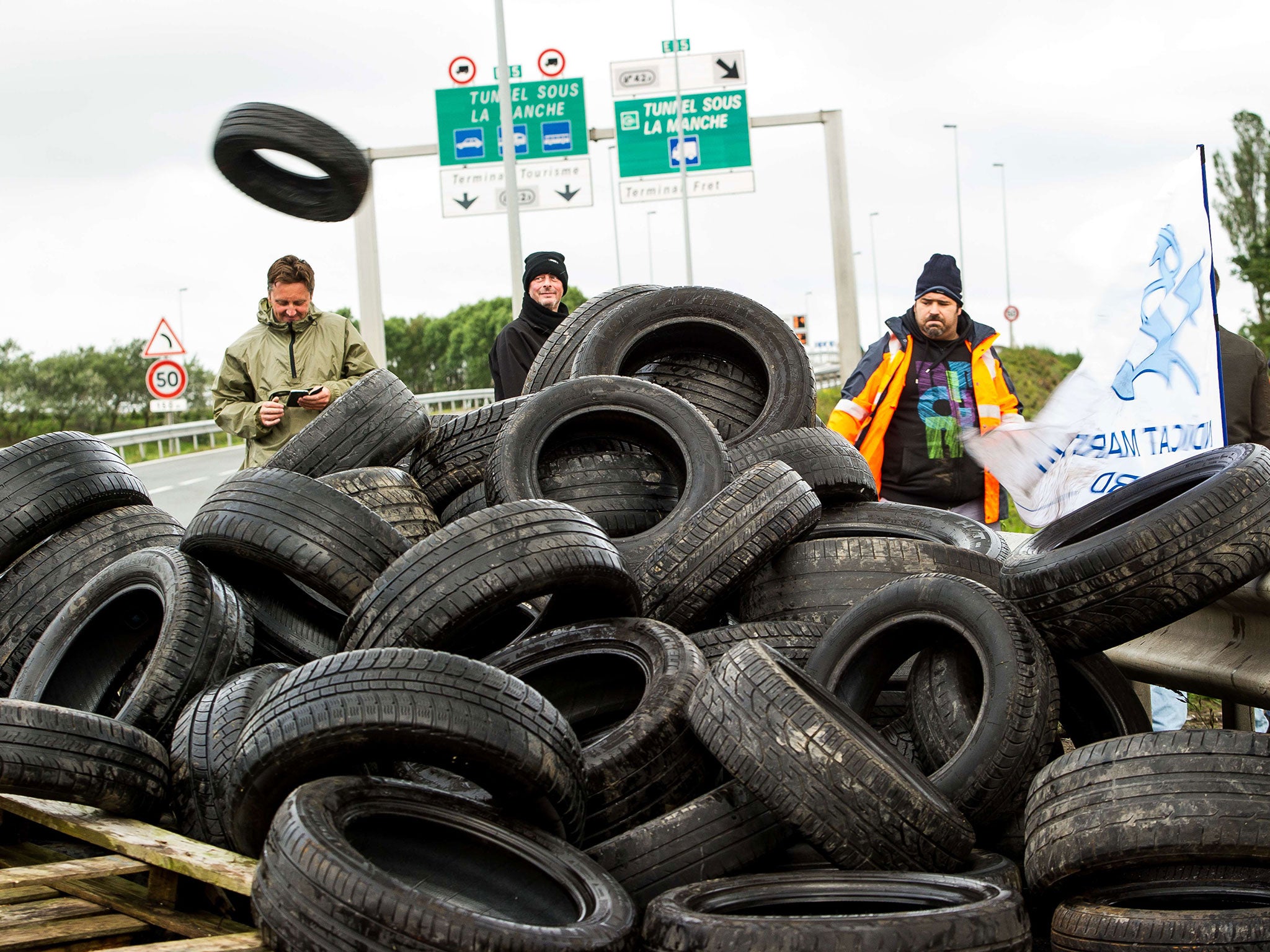 Striking employees of the French company My Ferry Link prepare to set tyres on fire to block the access to the Channel Tunnel