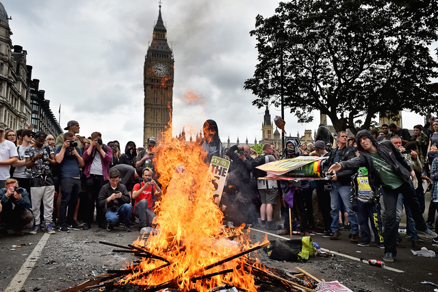 Protestors set fire to placards in central London during demonstrating against austerity and spending cuts on June 20, 2015 in London