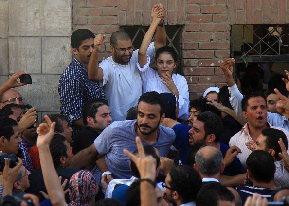 Jailed Egyptian sibling activists Alaa Abd El-Fattah and Sanaa Seif gesture after they were granted permission by authorities to attend the funeral of their father, prominent Egyptian human rights lawyer Ahmed Seif el-Islam, in Cairo in August, 2014