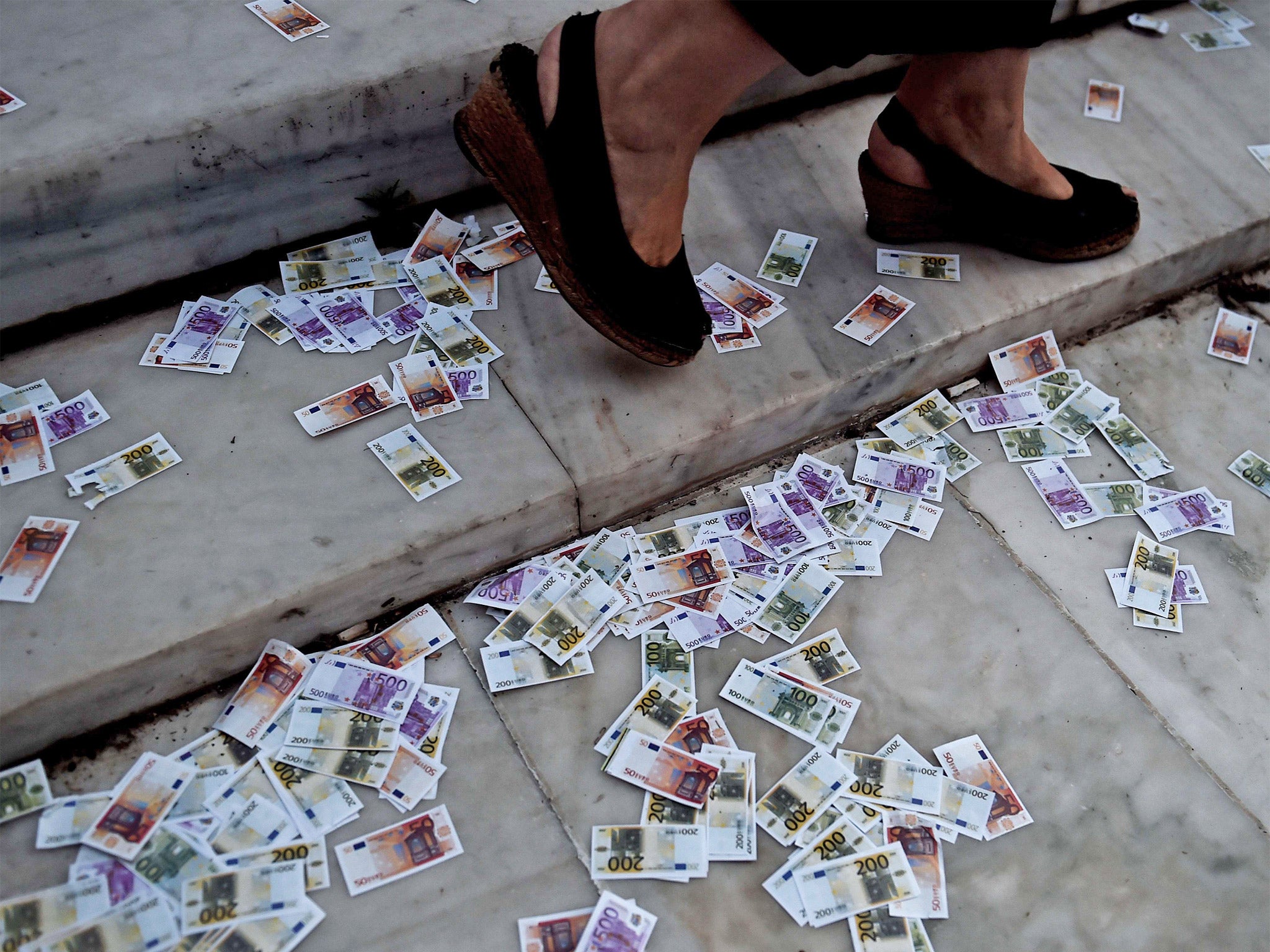 Fake euro notes litter the ground during a pro-European demonstration in front of the Greek parliament in Athens on Tuesday