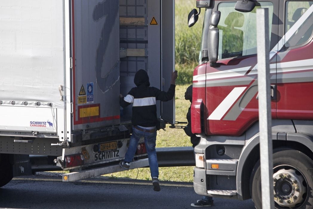 A migrant goes inside a lorry to attempt to cross the English Channel, in Calais, northern France, Wednesday, June 24, 2015. All trains and many ferry services between Britain and France were cut off Tuesday by striking port workers, stranding hundreds of