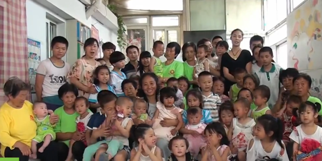 Ms Lijuan, pictured in centre, with her foster children - many who are sick, disabled and orphaned