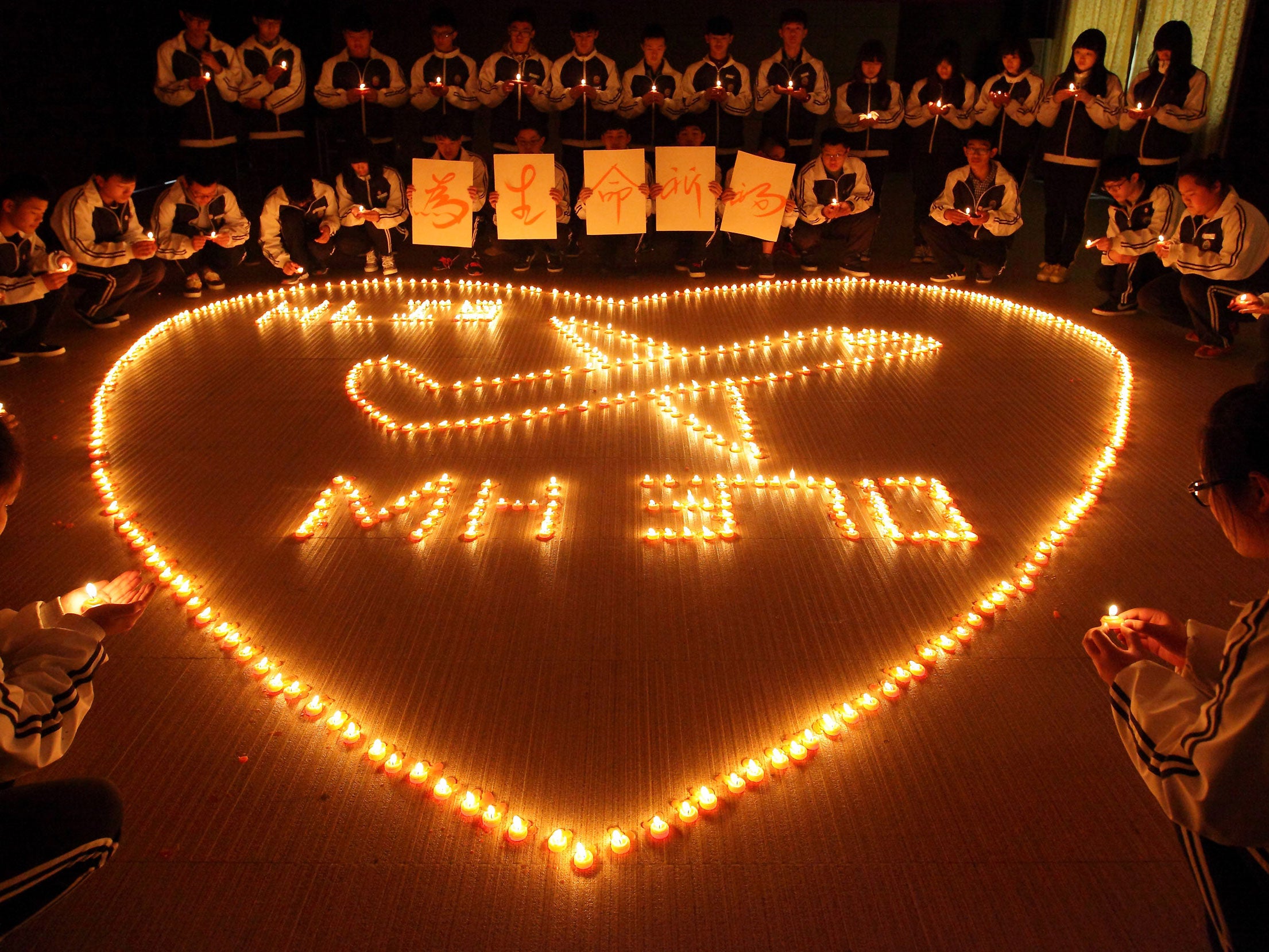 Children hold a vigil for the missing people who were on board MH370