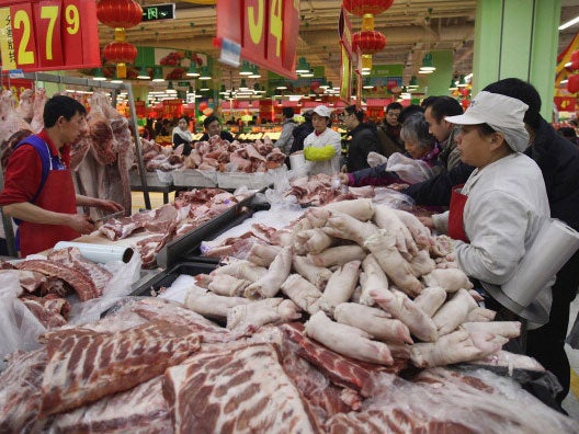 People buy meat at a market in Beijing