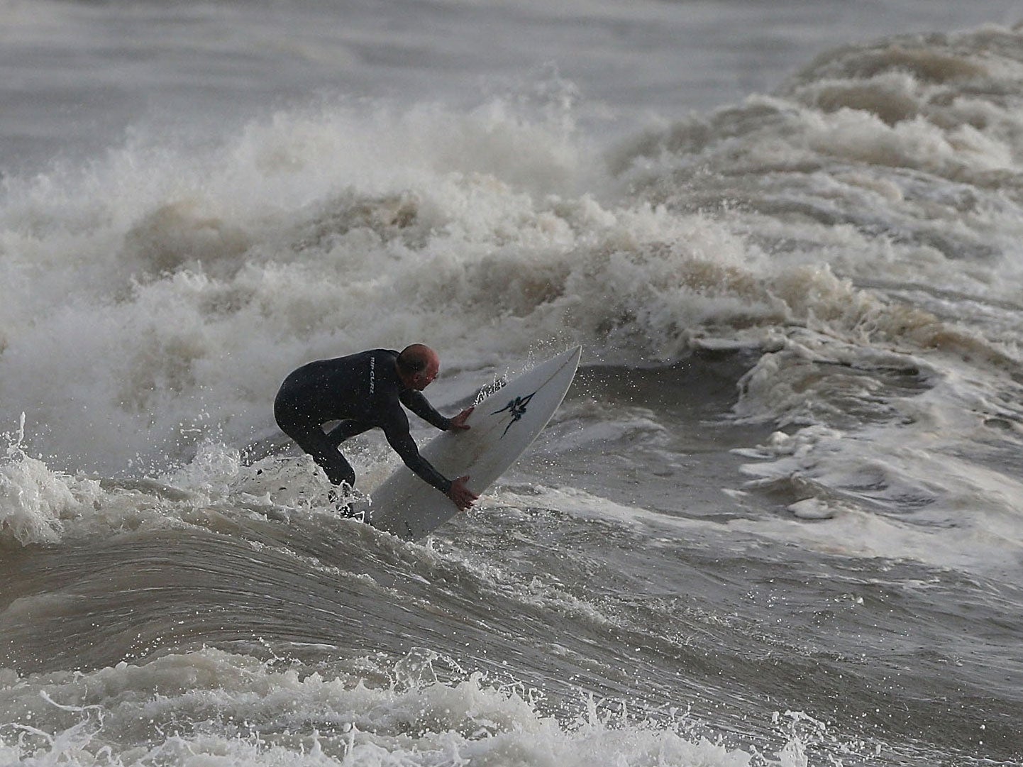 A man surfs in stormy seas in Sydney, Australia