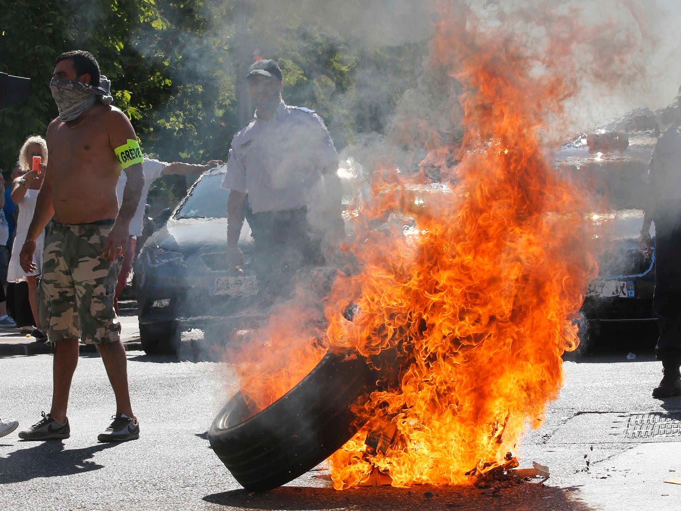Taxi drivers on strike burn tyres during a national protest against car-sharing service Uber in Marseille 